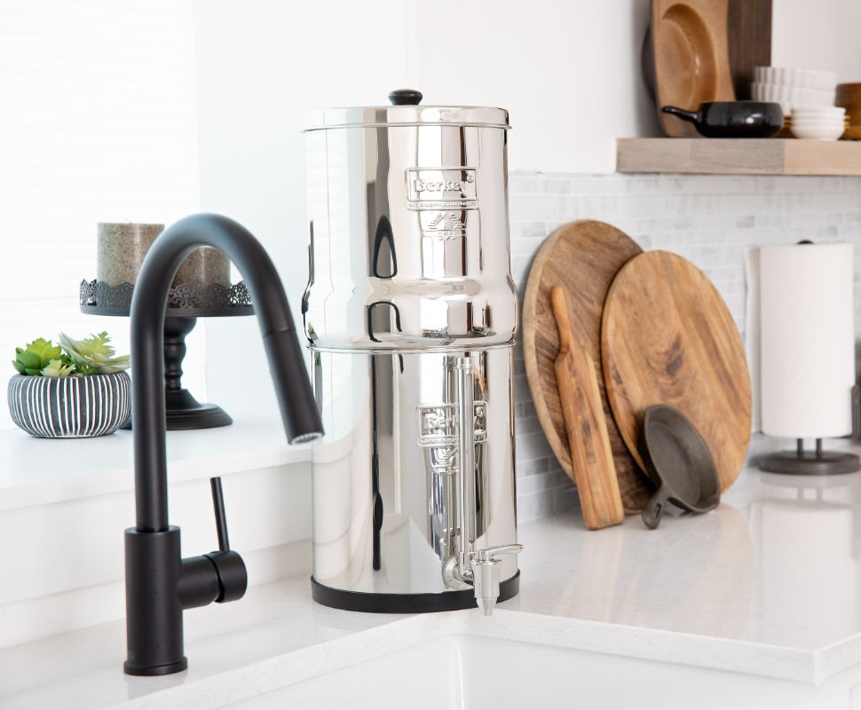 A Berkey Water Filter system filters water using gravity filters next to a sink.